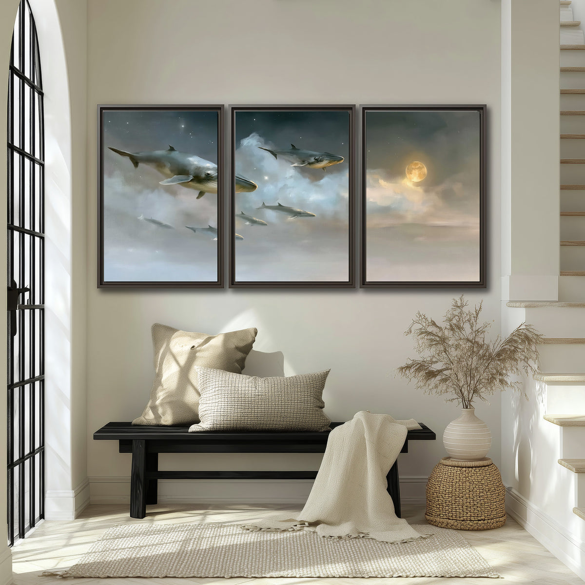 Whales drifting through pale dreamlike clouds toward a golden moon 3 piece framed canvas wall art displayed in a entryway