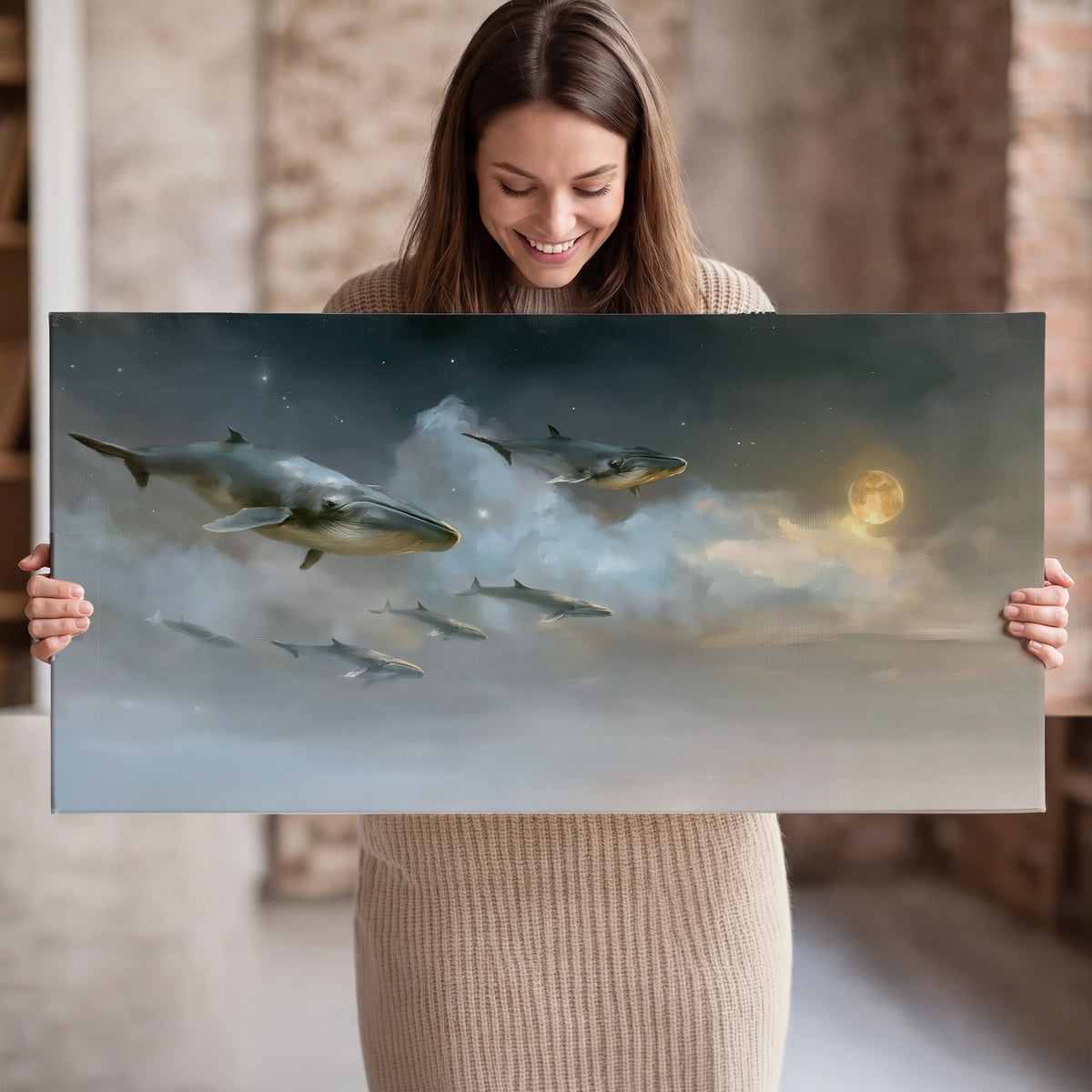 Whales drifting through pale dreamlike clouds toward a golden moon single canvas wall art held in hands