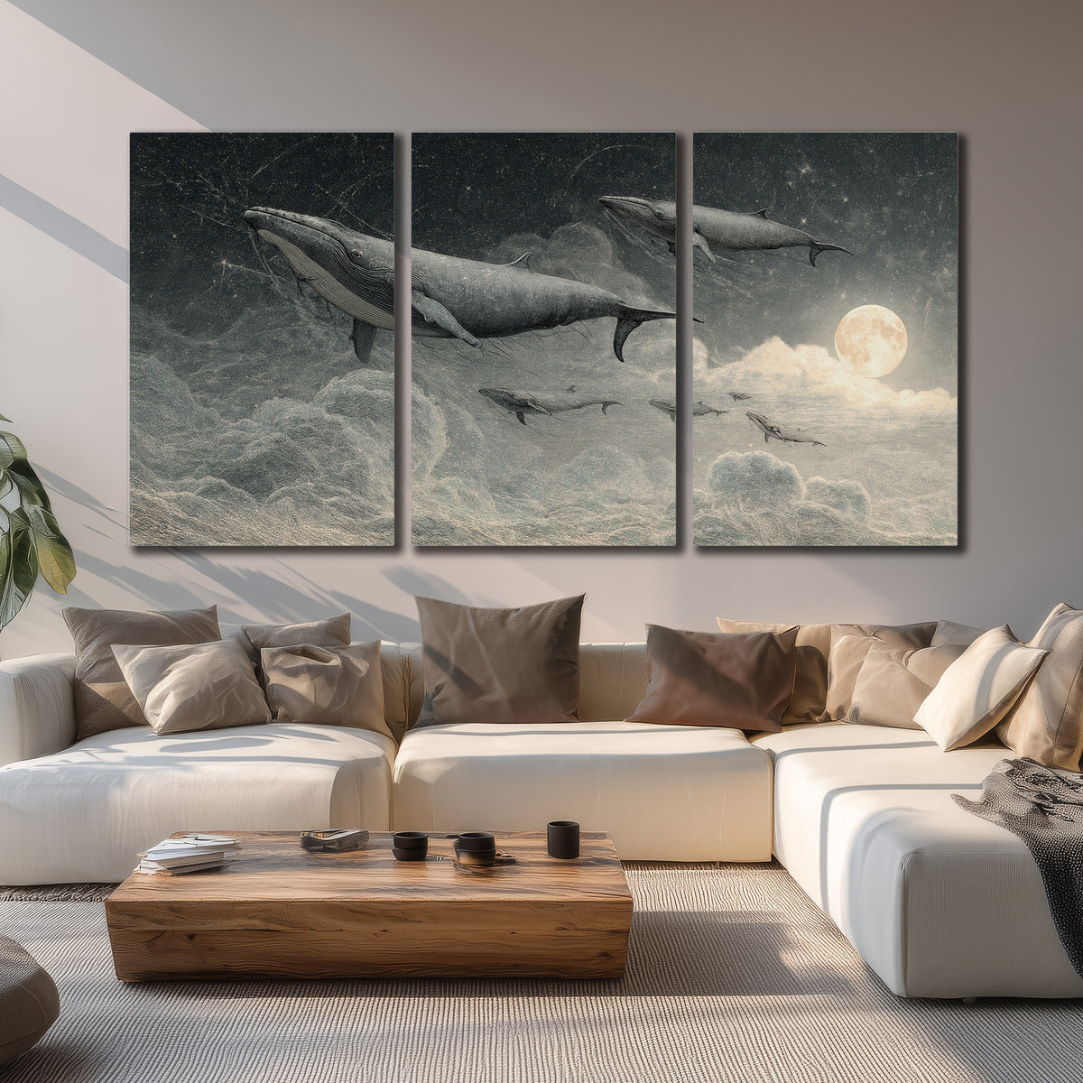 Monochrome whales floating over misty clouds beside a luminous painted moon 3 piece canvas wall art displayed in a living room
