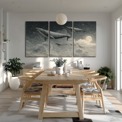 Monochrome whales floating over misty clouds beside a luminous painted moon 3 piece canvas wall art room and product view