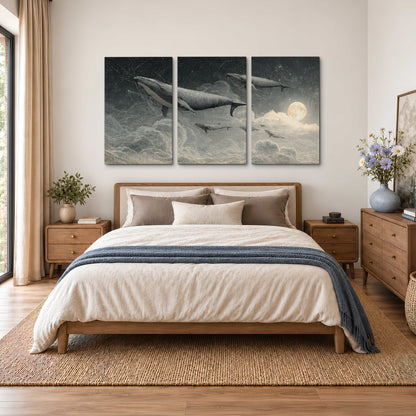 Monochrome whales floating over misty clouds beside a luminous painted moon 3 piece canvas wall art styled in an interior