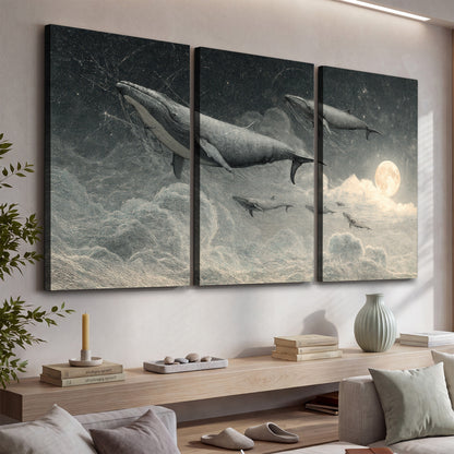 Monochrome whales floating over misty clouds beside a luminous painted moon 3 piece canvas wall art displayed in a console