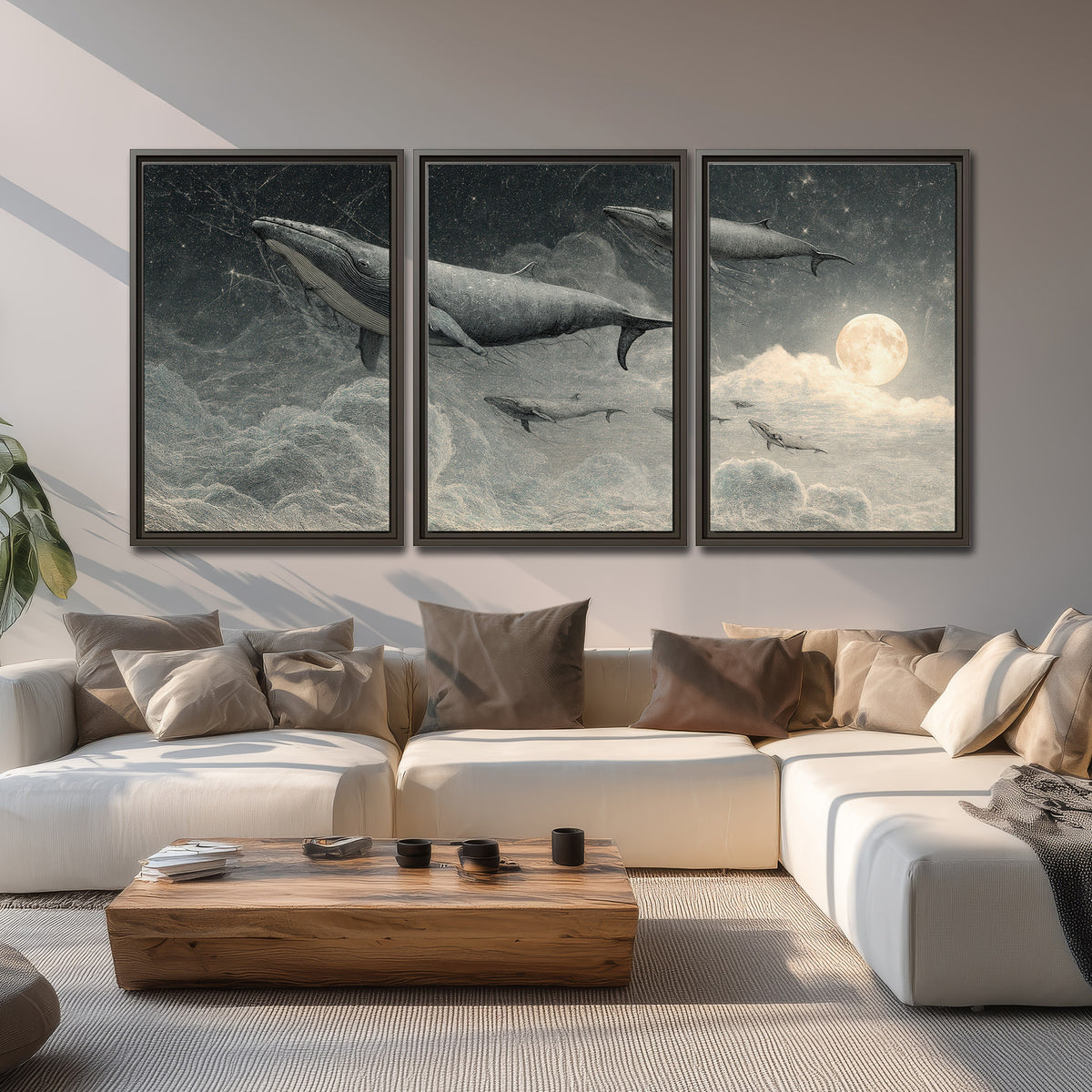 Monochrome whales floating over misty clouds beside a luminous painted moon 3 piece framed canvas wall art displayed in a living room