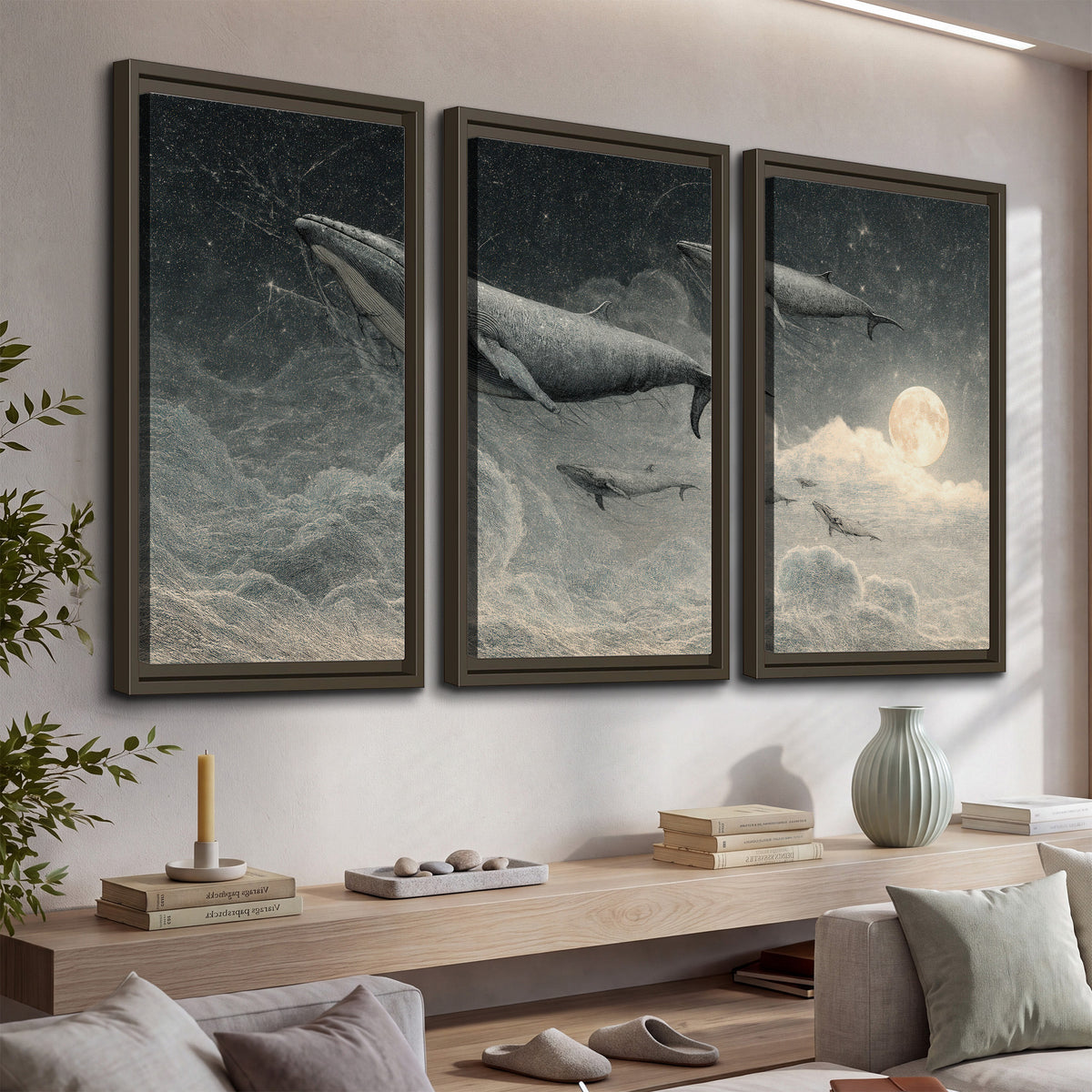 Monochrome whales floating over misty clouds beside a luminous painted moon 3 piece framed canvas wall art displayed in a console