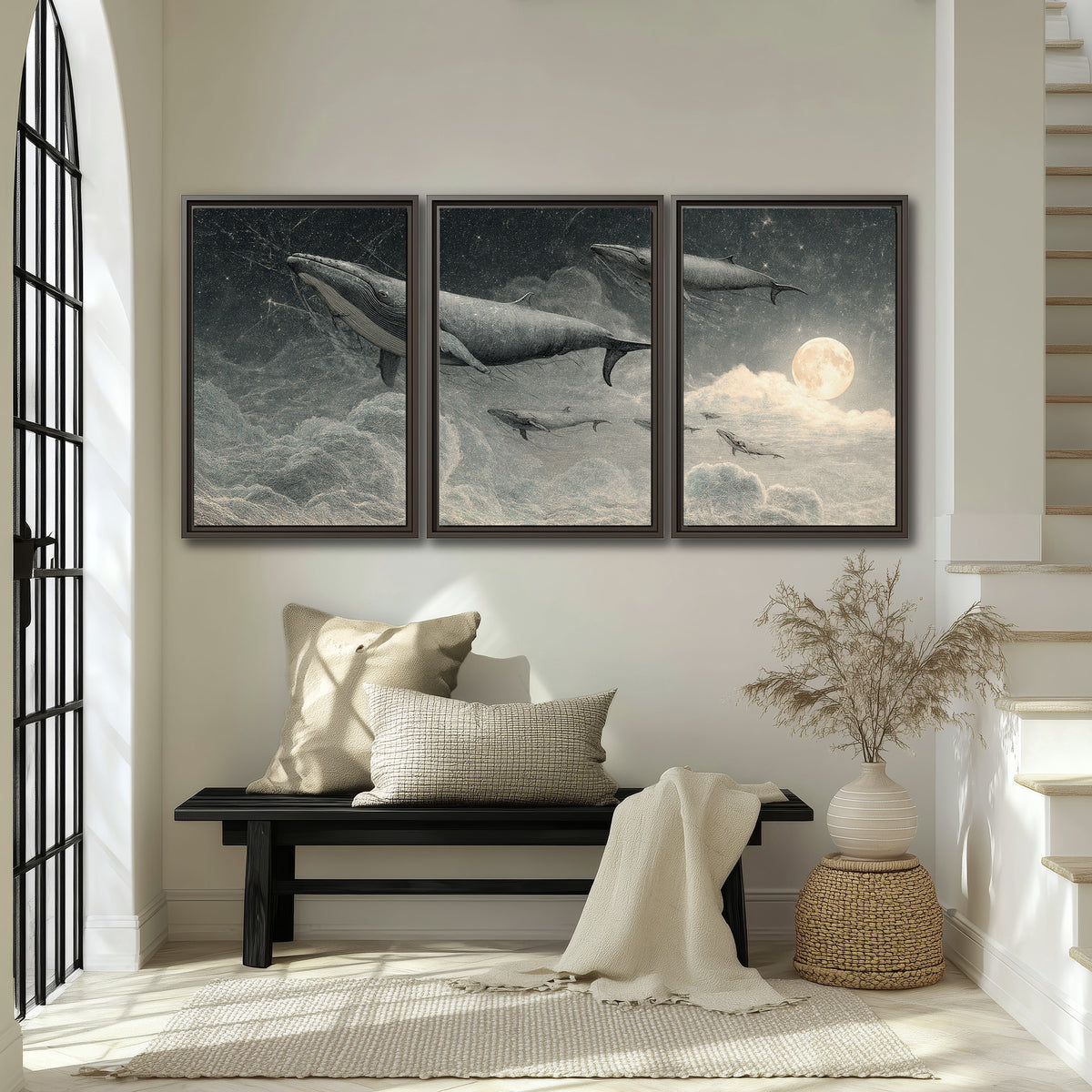 Monochrome whales floating over misty clouds beside a luminous painted moon 3 piece framed canvas wall art displayed in a entryway