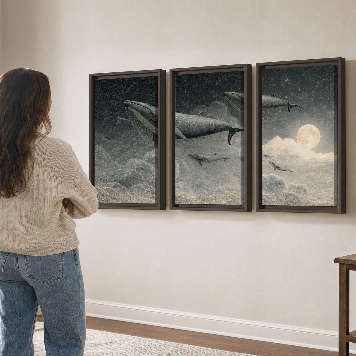 Monochrome whales floating over misty clouds beside a luminous painted moon 3 piece framed canvas wall art three panel arrangement on a wall