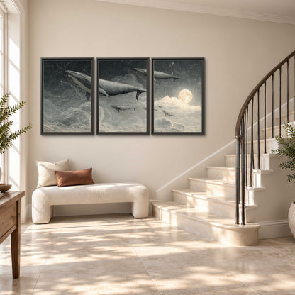 Monochrome whales floating over misty clouds beside a luminous painted moon 3 piece framed canvas wall art styled in an interior