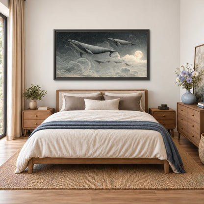 Monochrome whales floating over misty clouds beside a luminous painted moon single framed canvas wall art styled in an interior