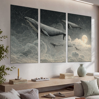 Monochrome whales floating over misty clouds beside a luminous painted moon set of 3 poster prints displayed in a console