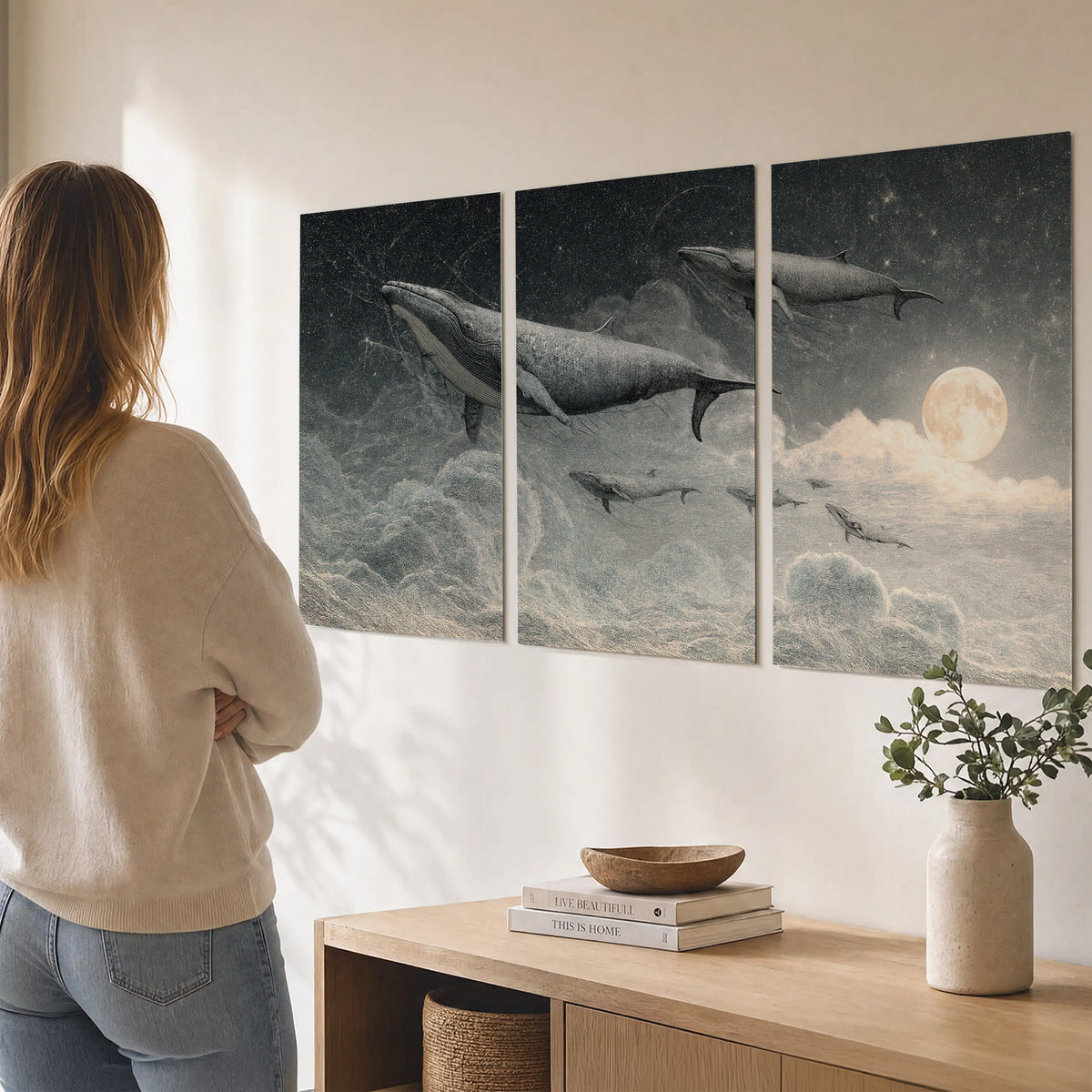 Monochrome whales floating over misty clouds beside a luminous painted moon set of 3 poster prints three panel arrangement on a wall