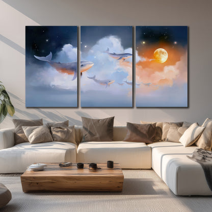 Blue whales gliding through pastel clouds beneath stars and a warm orange moon 3 piece canvas wall art displayed in a living room