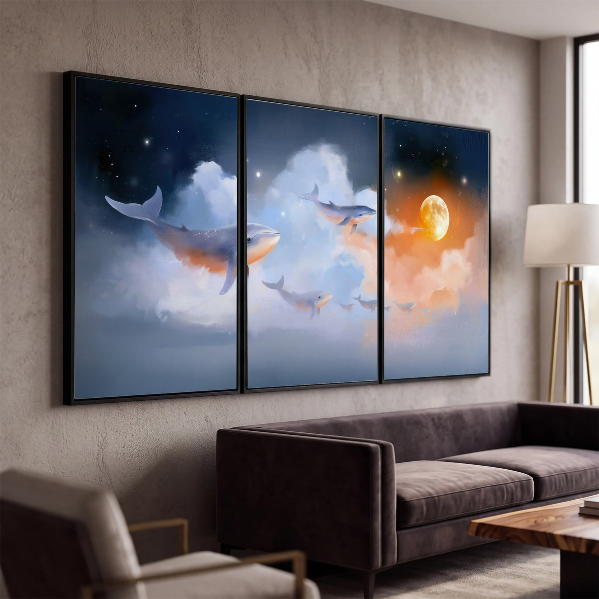 Blue whales gliding through pastel clouds beneath stars and a warm orange moon 3 piece framed canvas wall art displayed in a modern living room
