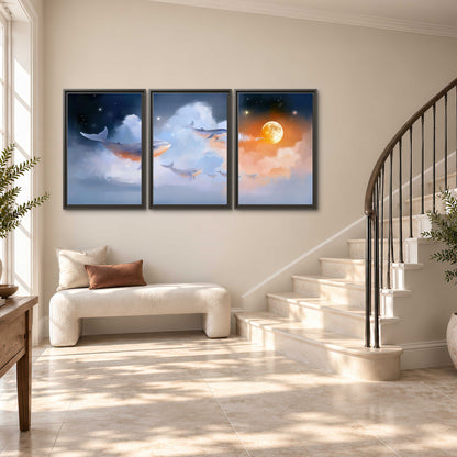 Blue whales gliding through pastel clouds beneath stars and a warm orange moon 3 piece framed canvas wall art styled in an interior