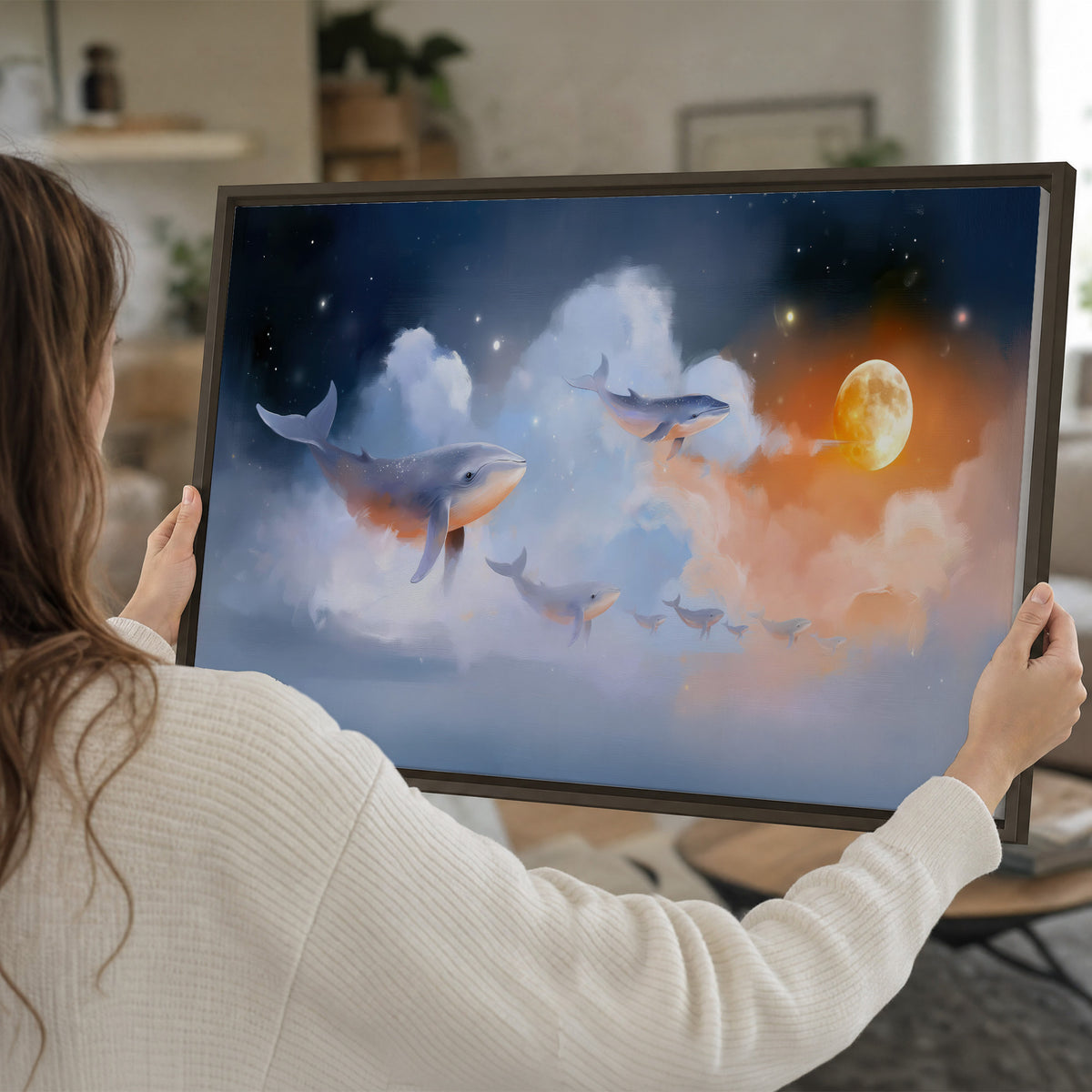 Blue whales gliding through pastel clouds beneath stars and a warm orange moon single framed canvas wall art held in hands