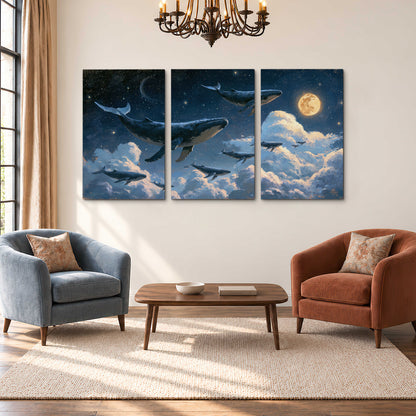 A group of whales floating among clouds beneath a golden moon in a deep blue night sky 3 piece canvas wall art styled in an interior