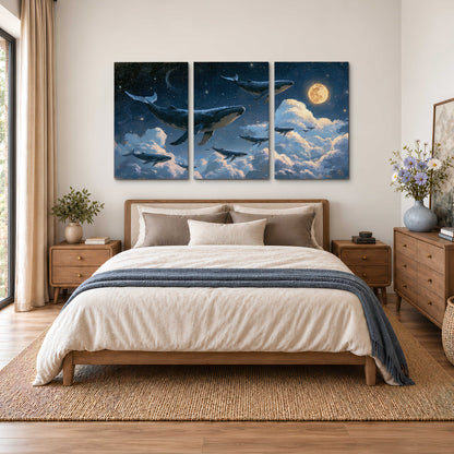 A group of whales floating among clouds beneath a golden moon in a deep blue night sky 3 piece canvas wall art styled in an interior