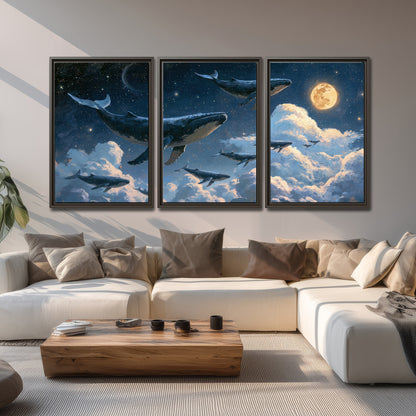 A group of whales floating among clouds beneath a golden moon in a deep blue night sky 3 piece framed canvas wall art displayed in a living room