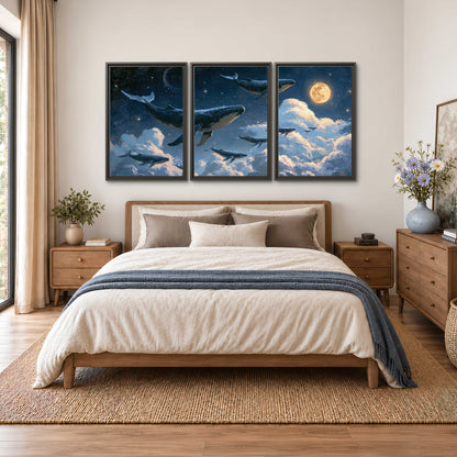 A group of whales floating among clouds beneath a golden moon in a deep blue night sky 3 piece framed canvas wall art styled in an interior