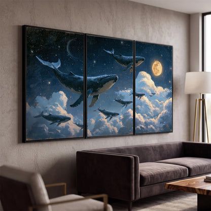 A group of whales floating among clouds beneath a golden moon in a deep blue night sky 3 piece framed canvas wall art displayed in a modern living room