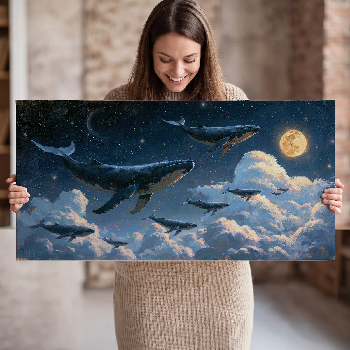 A group of whales floating among clouds beneath a golden moon in a deep blue night sky single canvas wall art held in hands