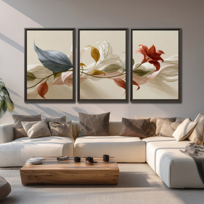 Ivory calla-like flowers and muted red accents curling across a cream background 3 piece framed canvas wall art displayed in a living room