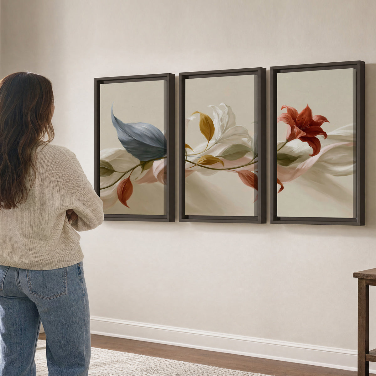 Ivory calla-like flowers and muted red accents curling across a cream background 3 piece framed canvas wall art three panel arrangement on a wall