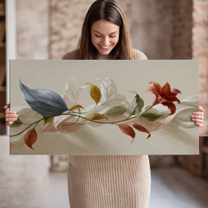 Ivory calla-like flowers and muted red accents curling across a cream background single canvas wall art held in hands