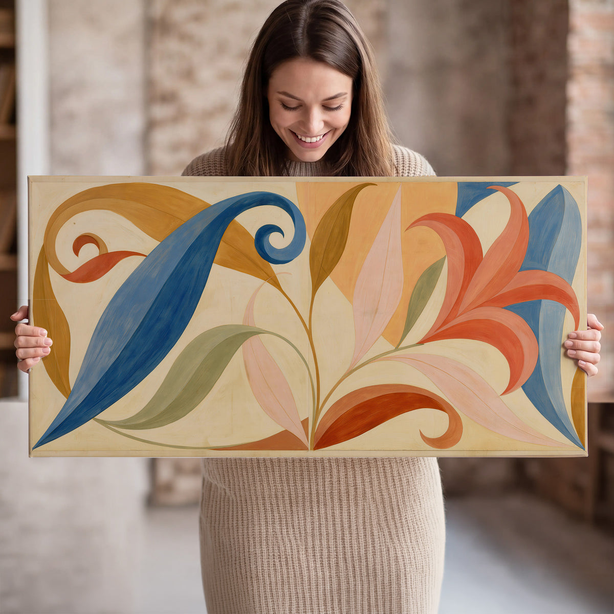 Bold blue, coral and golden leaf-like shapes flowing across a cream ground single canvas wall art held in hands