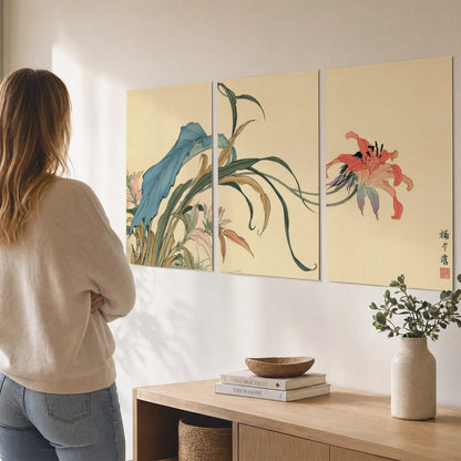 A delicate red flower and long blue-green leaves on a warm cream ground set of 3 poster prints three panel arrangement on a wall