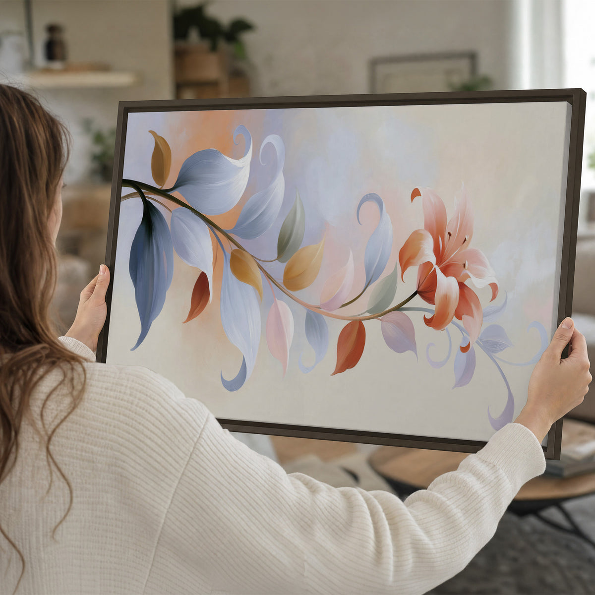 Peach blossoms and blue-green leaves in an airy cream-colored composition single framed canvas wall art held in hands