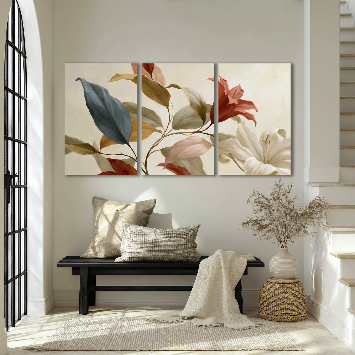 Cream flowers with broad blue and rust leaves sweeping across a neutral background 3 piece canvas wall art displayed in a entryway