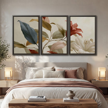 Cream flowers with broad blue and rust leaves sweeping across a neutral background 3 piece framed canvas wall art displayed in a bedroom