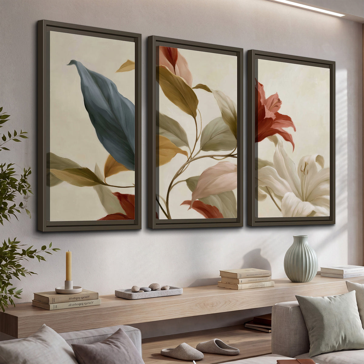 Cream flowers with broad blue and rust leaves sweeping across a neutral background 3 piece framed canvas wall art displayed in a console