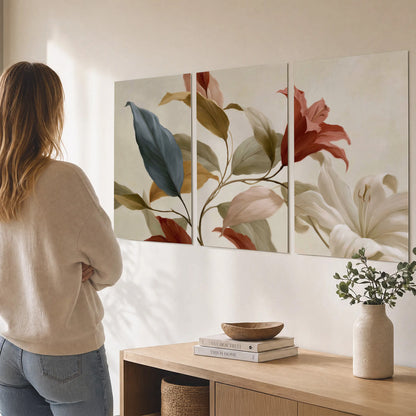 Cream flowers with broad blue and rust leaves sweeping across a neutral background set of 3 poster prints three panel arrangement on a wall