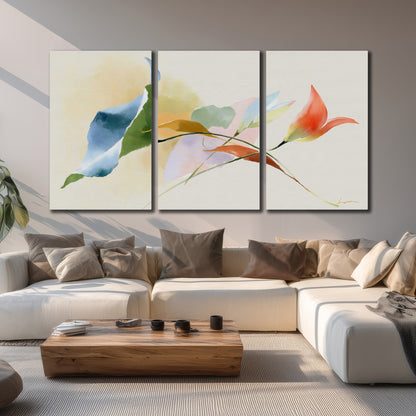 Airy green, orange and blue organic shapes floating across a white background 3 piece canvas wall art displayed in a living room