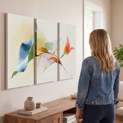 Airy green, orange and blue organic shapes floating across a white background 3 piece canvas wall art three panel arrangement on a wall