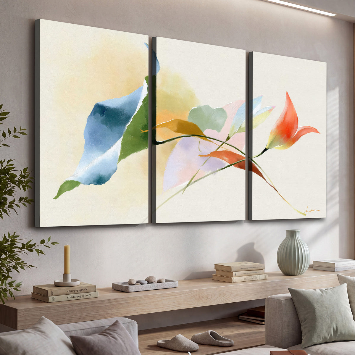Airy green, orange and blue organic shapes floating across a white background 3 piece canvas wall art displayed in a console