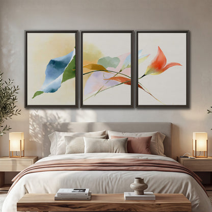 Airy green, orange and blue organic shapes floating across a white background 3 piece framed canvas wall art displayed in a bedroom