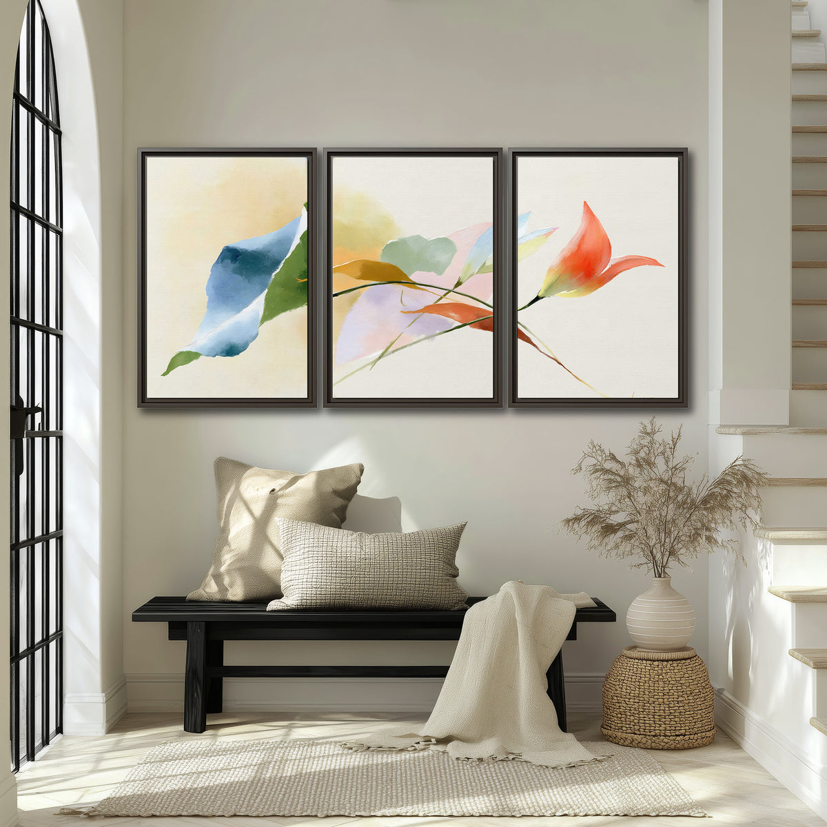 Airy green, orange and blue organic shapes floating across a white background 3 piece framed canvas wall art displayed in a entryway