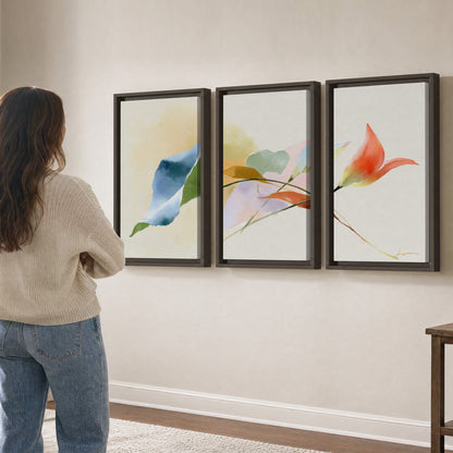 Airy green, orange and blue organic shapes floating across a white background 3 piece framed canvas wall art three panel arrangement on a wall