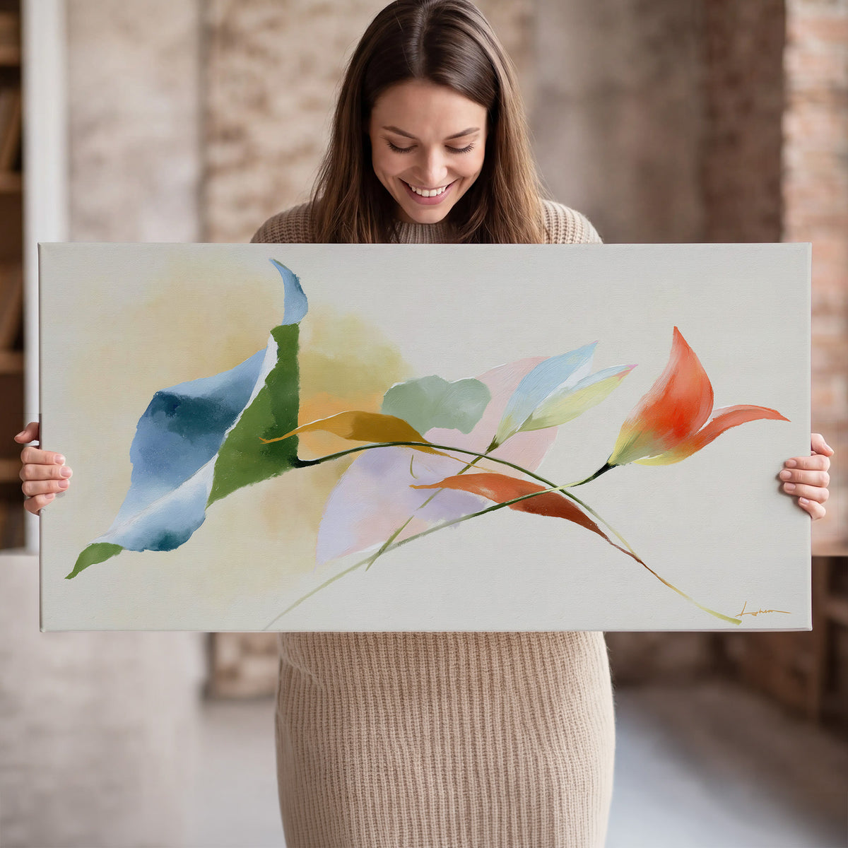 Airy green, orange and blue organic shapes floating across a white background single canvas wall art held in hands
