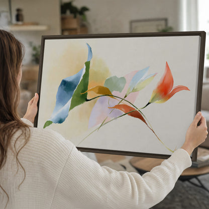 Airy green, orange and blue organic shapes floating across a white background single framed canvas wall art held in hands