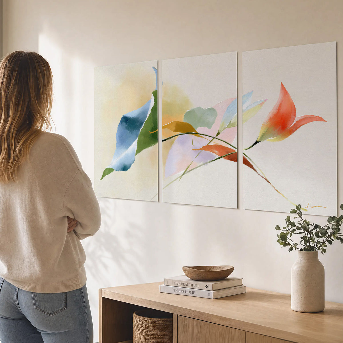 Airy green, orange and blue organic shapes floating across a white background set of 3 poster prints three panel arrangement on a wall