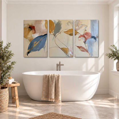 Loose ochre, blue and pink leaves arranged on a pale layered background 3 piece canvas wall art styled in an interior