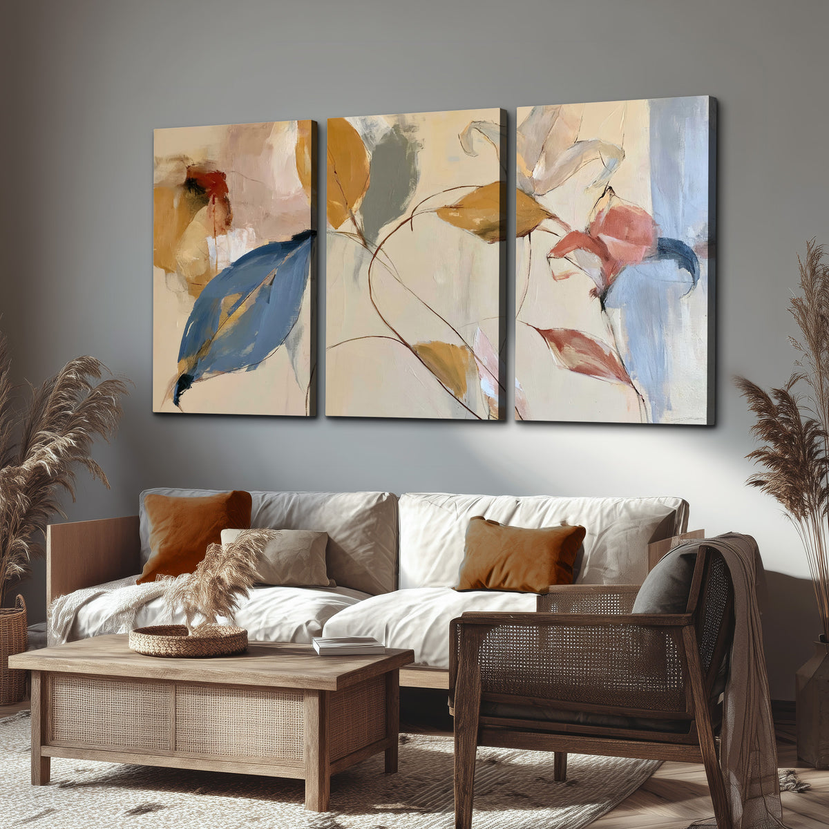 Loose ochre, blue and pink leaves arranged on a pale layered background 3 piece canvas wall art displayed in a rustic living room