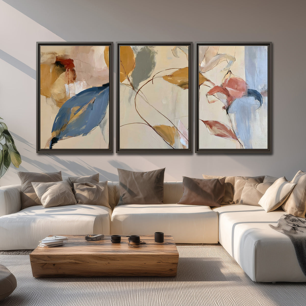 Loose ochre, blue and pink leaves arranged on a pale layered background 3 piece framed canvas wall art displayed in a living room
