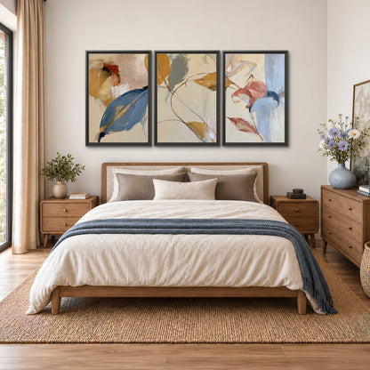 Loose ochre, blue and pink leaves arranged on a pale layered background 3 piece framed canvas wall art styled in an interior