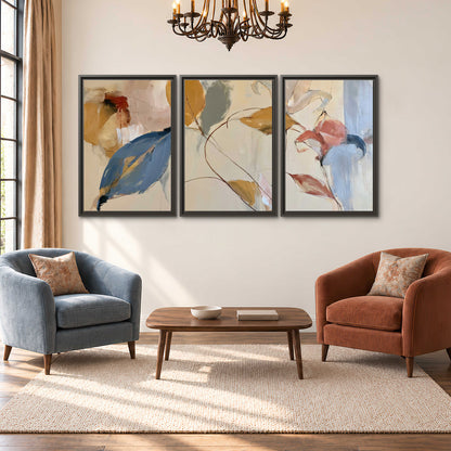 Loose ochre, blue and pink leaves arranged on a pale layered background 3 piece framed canvas wall art styled in an interior