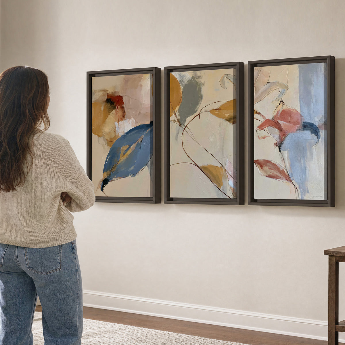 Loose ochre, blue and pink leaves arranged on a pale layered background 3 piece framed canvas wall art three panel arrangement on a wall