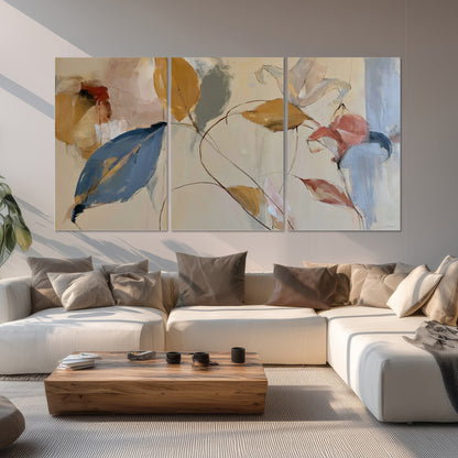 Loose ochre, blue and pink leaves arranged on a pale layered background set of 3 poster prints displayed in a living room